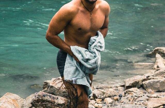 Person wrapping in a warm towel to rewarm after a cold plunge session